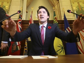 Prime Minister Justin Trudeau adjusts his microphones before speaking during a Liberal caucus meeting on Parliament Hill on Nov. 5, 2015. (REUTERS/Chris Wattie)