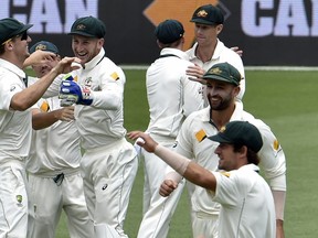 Australia players celebrate their victory against New Zealand on the fifth and the final day of their first Test cricket match in Brisbane on Wednesday. (AFP PHOTO)