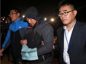 In this April 19, 2014 file photo, Lee Joon-seok, centre, the captain of the sunken ferry Sewol in the water off the southern coast, leaves a court which issued his arrest warrant in Mokpo, south of Seoul, South Korea. South Korea's top court on Thursday, Nov. 12, 2015, upheld a lifetime sentence for the captain of the ferry that sank last year, killing more than 300 people, most of them teenagers on a school trip. (Yonhap via AP, File)