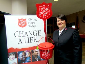 Capt. Nancy Braye stands by one of the iconic red kettles at the Salvation Army on Thursday November 12, 2015 in Sarnia, Ont. (Paul Morden, The Observer)
