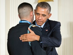 President Barack Obama and Florent Groberg embrace after Obama bestowed the nation's highest military honor, the Medal of Honor to Groberg, Thursday, Nov. 12, 2015, during a ceremony in the East Room of the White House in Washington. (AP/Pablo Martinez Monsivais)