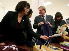 Alberta Culture and Tourism Minister David Eggen (centre) wraps up a Christmas toy package joined representatives from various Edmonton area charitable organizations to highlight the great work the local do in the Capital region. As well Eggen pointed out the benefits that donors receive during tax time through their Charitable Donations Tax Credit. Tom Braid/Edmonton Sun