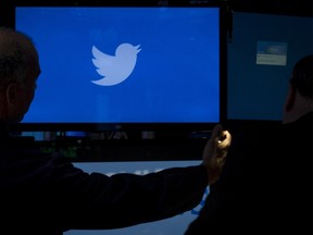 An employee adjusts a screen that displays the Twitter logo ahead of the company's IPO on the floor of the New York Stock Exchange, in this file picture taken November 6, 2013. Twitter Inc said it would lay off up to 336 employees, or about 8 percent of its global workforce, as part of a plan to streamline operations.    REUTERS/Brendan McDermid/Files