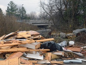 A pile of discarded building material more than a metre high sits within eye-shot of Bruce MacNabb Bridge on Nov. 12, 2015. Its discovery is inciting outrage by Barrhaven's Councillor, Jan Harder. (SAM COOLEY Ottawa Sun / Postmedia Network)
