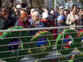 Members of the public gather to view wreaths following the Remembrance Day ceremony at the Cenotaph in Victoria Park in London, Ont. on Wednesday November 11, 2015. (CRAIG GLOVER, The London Free Press)