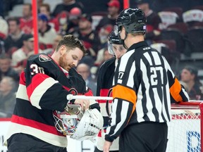 Ottawa Senators goalie Andrew Hammond (30) fixes his helmet after blocking a shot with his head in the second period against the Vancouver Canucks at Canadian Tire Centre on Nov. 12, 2015. Marc DesRosiers-USA TODAY Sports