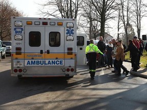 A young girl is escorted to an ambulance on November 11 at the Remembrance Day Parade presentation, she is one of five students from Seaforth to faint that day.(Shaun Gregory/Huron Expositor)