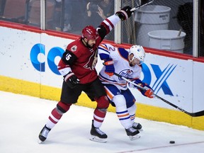 Nov 12, 2015; Glendale, AZ, USA; Arizona Coyotes center Boyd Gordon (15) and Edmonton Oilers defenseman Andrej Sekera (2) battle for the puck during the third period at Gila River Arena. Mandatory Credit: Matt Kartozian-USA TODAY Sports