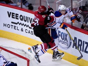 Arizona Coyotes left wing Anthony Duclair (10) checks Edmonton Oilers defenceman Brandon Davidson (88) during the first period at Gila River Arena on Thursday. (USA TODAY SPORTS)