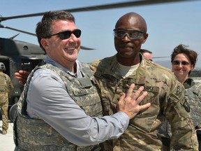 In this photo provided by the Department of Defense, then-U.S. Army Brig. Gen. Ron Lewis, right, greets then-Deputy Secretary of Defense Ash Carter, left, in Jalalabad, Afghanistan, May 13, 2013. Defense Secretary Ash Carter suddenly fired Lt. Gen. Ron Lewis, his top military aide Thursday, Nov. 12, 2015, citing allegations of misconduct, and referred the matter to the department's inspector general. Defence officials would not provide any details about why Lewis was removed from his job. A senior defence official said Carter learned of the allegations Nov. 10 and later informed the inspector general. (Glenn Fawcett/DOD via AP)