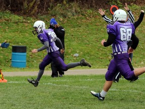 Ingersoll District Collegiate Institute Blue Bombers running back Dawson Pacheco, left, gets past a Huron Park Secondary School Huskies defender to score the game winning touchdown in Ingersoll, Ont. on Thursday November 12, 2015. The Blue Bombers won 14-8 with a touchdown with 7.3 seconds remaining to claim the TVRA varsity football division 'B' championship. Greg Colgan/Woodstock Sentinel-Review/Postmedia Network