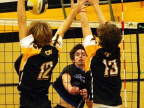 Ingersoll District Collegiate Institute Blue Bomber Connor Hutchison, centre, sends the ball past two Central Elgin Collegiate Institute Titans players in St. Thomas, Ont. on Thursday November 12, 2015. IDCI lost three sets to two (22-25, 25-10, 25-23, 18-25, 10-15) in the TVRA senior boys' southeast division finals to Central Elgin. Greg Colgan/Woodstock Sentinel-Review/Postmedia Network