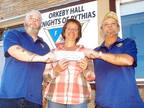 Knights of Pythias members Jerry Blake, left, and Robert Micks, right, accept a donation from Wallaceburg resident Melody for $125, to go towards this Saturday's (Nov. 14) Santa Claus parade. The parade starts at Arnold Street and Dufferin Avenue at 2 p.m. and moves east towards James Street and then to Nelson Street.