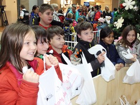 Children from Carl A. Nesbitt Public School show off their food donations at a press conference to launch the Edgar Burton Christmas Food Drive on Friday. Ben Leeson/The Sudbury Star/Postmedia Network