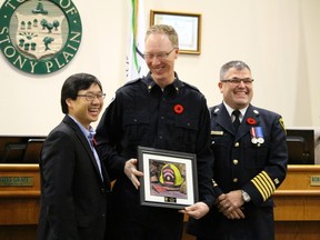 Stony Plain's finest — and tallest. One service member has a laugh with Mayor William Choy about his height as Stony Plain town council honoured service men and women for their hard work at council meeting on Nov. 10.  - Mitch Goldenberg, Reporter/Examiner