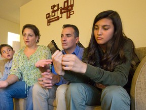 Johanna Regalado describes how her husband, Edgar, was shot at by a man on a motorcycle in Colombia after he denied a FARC member a bank loan. She is sitting with their son, Juan, 8, and daughter, Laura, 13, in their apartment in London. (CRAIG GLOVER, The London Free Press)