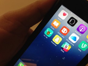 The Yik Yak app, lower, left, is seen on an iPhone in Washington, Wednesday, Nov. 11, 2015. Internet users of the Yik Yak social media gossip app popular among college students aren't nearly as anonymous as they believe: Missouri police within hours arrested a student accused of threatening violence, the latest in a string of such arrests at colleges in recent months involving threats posted online.  (AP Photo/Ronald Lizik)