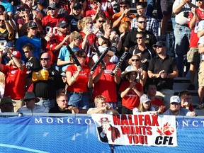 A sign asking for a team in Halifax is draped over a wall in front of fans attending a game between the Stampeders and Tiger-Cats in Moncton, N.B., on Sept. 25, 2011. (Paul Darrow/Reuters/Files)