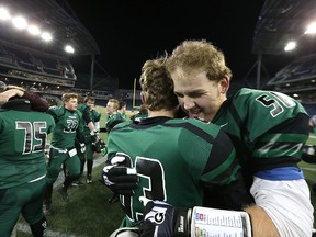 Vincent Massey Trojans OL Corin Plas hugs a teammate after beating the St. Paul's Crusaders in the WHSFL AAA championship game. (Kevin King/Winnipeg Sun)