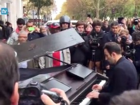 A man played John Lennon's "Imagine" outside the Bataclan concert hall on Saturday where at least 87 people were killed the day before in a terror attack. (RepTV video screenshot)