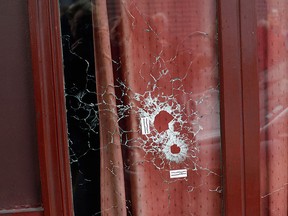 Bullet holes mark the front window of the Carillon cafe, in Paris, Saturday, Nov. 14, 2015. (AP Photo/Thibault Camus)