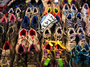 A participant number tag is seen among running shoes left at the makeshift memorial following the 2013 Boston Marathon bombings, in an exhibit titled "Dear Boston: Messages from the Marathon Memorial" at the Boston Public Library in Boston, Mass.,s in this file photo from April 16, 2014.      REUTERS/Brian Snyder/Files