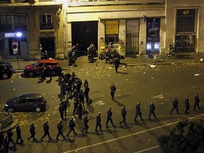 French police with protective shields walk in line near the Bataclan concert hall following fatal shootings in Paris, France, November 14, 2015. Gunmen and bombers attacked busy restaurants, bars and a concert hall at locations around Paris on Friday evening, killing dozens of people in what a shaken French President described as an unprecedented terrorist attack.  REUTERS/Christian Hartmann