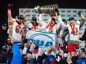 Guelph Gryphons football players Matthew Nesbitt, left, James Ingram, Curtis Newton, John Rush, James Roberts and Patrick McGrath hoist the OUA Yates Cup over their heads after winning the provincial championship football game by beating the Western Mustangs 23-17 at TD Stadium in London, Ont. on Saturday November 14, 2015. Craig Glover/The London Free Press/Postmedia Network