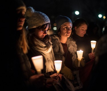 Young women hold candles at a vigil outside of the French Embassy in Ottawa for the victims of the terrorist attack in France. Saturday November 14, 2015. Errol McGihon/Ottawa Sun/Postmedia Network