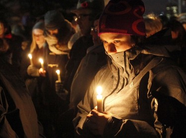 A women holds a candle at the French embassy during a vigil in Ottawa on November 14, 2015, one day after the terrorist attacks in Paris. Stirring renditions of "La Marseillaise" rang out Saturday from Dublin to New York as global landmarks were bathed in the French colors and thousands marched in solidarity with Paris after attacks that left at least 129 dead. AFP Photo/Patrick Doyle
