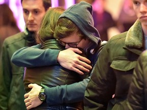 Deborah Weber (L) hugs Frederic Bidot (C) during a vigil in San Francisco, California on November 14, 2015, one day after the Paris terrorist attacks.