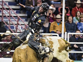 Tyler Thomson takes part in the bull riding event during the 42nd Canadian Finals Rodeo at Rexall Place in Edmonton, Alta., on Saturday, Nov. 14, 2015. Codie McLachlan/Edmonton Sun/Postmedia Network