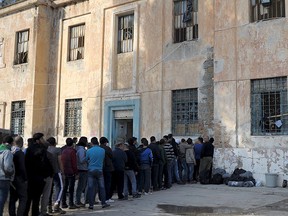 Refugees and migrants line-up during free food distribution at a temporary camp on the Greek island of Leros Nov. 15, 2015. The holder of a Syrian passport found near the body of one of the gunmen who died in Friday night's attacks in Paris was registered as a refugee in several European countries last month, authorities said. REUTERS/Fotis Plegas