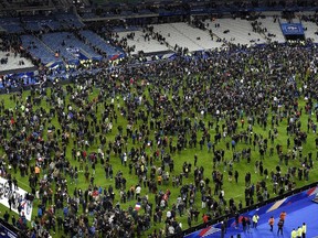 Football fans gather on the field of the Stade de France stadium following the friendly football match between France and Germany in Saint-Denis, north of Paris, on Nov. 13, 2015, after a series of gun attacks across Paris as well as explosions outside the national stadium where France was hosting Germany. (AFP PHOTO/FRANCK FIFE)