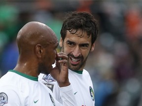 Cosmos player Raul (R) speaks with teammate Marcos Senna (L) during a recent NASL soccer match.  AFP PHOTO / Kena Betancur