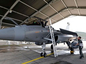 French soldiers and pilots work on a Rafale jet fighter at the air base in Mont de Marsan, southwestern France, Aug. 31, 2015.  REUTERS/Regis Duvignau