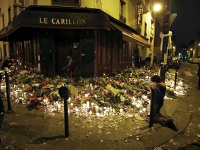 People pray outside Le Carillon restaurant, one of the attack sites in Paris, November 15, 2015.    REUTERS/Jacky Naegelen