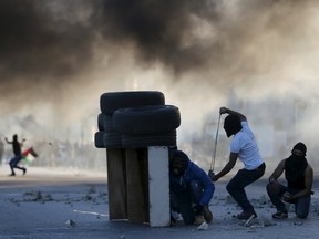 Palestinian protesters take cover during clashes with Israeli troops near the Jewish settlement of Bet El, near the West Bank city of Ramallah November 13, 2015. REUTERS/Mohamad Torokman