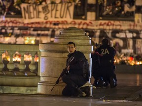 French police officers take position on Place de la Republique (Republic Square), after an allegedly false alert sparked mass panic amongst the gathered crowd in Paris, Sunday, Nov. 15, 2015. Thousands of French troops deployed around Paris on Sunday and tourist sites stood shuttered in one of the most visited cities on Earth while investigators questioned the relatives of a suspected suicide bomber involved in the country's deadliest violence since World War II. (AP Photo/Kamil Zihnioglu)