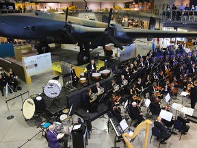 The Quinte Symphony performs before the National Air Force Museum of Canada's restored Halifax bomber in Trenton Sunday. An estimated 750 people attended the Tribute to the Brave concert, which also featured the 8 Wing Concert Band and the 8 Wing Pipes and Drums. Proceeds from the concert, performed in honour of late area MPP Hugh O'Neil, are to be divided between the museum and symphony.