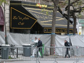 A forensic expert (L) and policemen walk at the secured and cordoned off crime scene of the Bataclan concert hall is pictured on November 14, 2015 following the deadly attacks in Paris a day before. The string of coordinated attacks in and around Paris late November 13, 2015 left more than 120 people dead, in the worst such violence in France's history. AFP PHOTO / JACQUES DEMARTHON