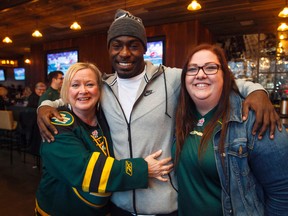 Eskimos fans Annette Grochmal (left) and Tara Lyon get their photo taken with running back Greg Morris while watching the West Semi-Final between the Calgary Stampeders and the BC Lions during an Edmonton Eskimos watching party at Central Social Hall in Edmonton. (IAN KUCERAK/Edmonton Sun)