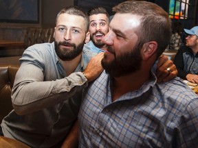 Eskimos Mike Reilly (left), Nate Coehoorn (centre) and Brian Ramsay joke around while watching the CFL West Semi-Final at Central Social Hall on Sunday.