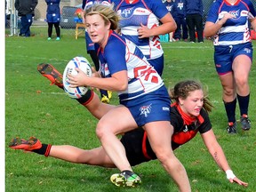 Loyalist College Player of the Game, Morgan Houde-Pearce of Trenton, evades a St. Lawrence tackler during OCAA women's rugby bronze medal match Sunday in Kingston. (Catherine Frost for The Intelligencer)