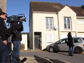 Journalists stand in front of the house where neighbors say French suicide bomber Ismael Omar Mostefai lived with his family until about two years ago in Chartres, France, Sunday, Nov. 15, 2015. Thousands of French troops deployed around Paris on Sunday and tourist sites stood shuttered in one of the most visited cities on Earth while investigators questioned the relatives of a suspected suicide bomber involved in the country's deadliest violence since World War II. (AP Photo/Michel Spingler)