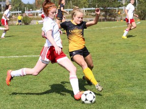 Cambrian College Golden Shield's Courtney Ceccarelli battles for the ball against Loyalist College's Emily McMullan during women's varsity soccer action at Cambrian College in Sudbury, Ont. on Sunday September 13, 2015.