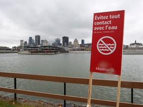 A sign warns to avoid contact with the water along the shore of the St. Lawrence River Friday, November 13, 2015 in Montreal. The city is in the process of dumping eight billion litres of raw sewage into the river while repairs are being made to the sewage collectors. THE CANADIAN PRESS/Ryan Remiorz