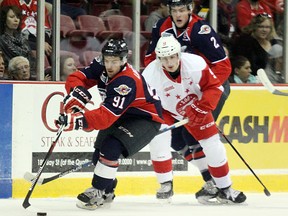 Windsor Spitfires forward Aaron Luchuk, left, and Soo Greyhounds forward Zachary Senyshyn battle for the puck as Spitfires defenceman Patrick Sanvido looks on  during OHL action in Sault Ste. Marie on Sept. 25. (Postmedia Network)