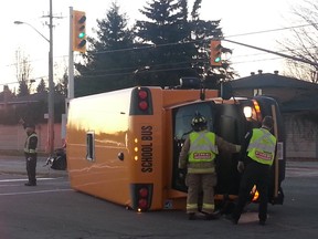 A school bus toppled over after a crash at the intersection of Hunt Club Rd. at Paul Anka Dr. in south Ottawa Monday afternoon, Nov. 16, 2015. 
JULIENNE BAY/Ottawa Sun