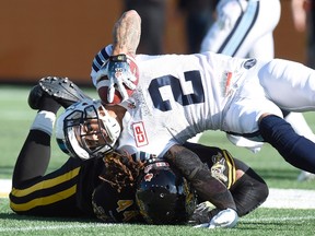 Toronto Argonauts receiver Chad Owens (2) goes down as he’s tackled by Hamilton Tiger-Cats defender Taylor Reed (44) during the CFL Eastern Division semifinal in Hamilton on Sunday, Nov. 15, 2015. (THE CANADIAN PRESS/Frank Gunn)